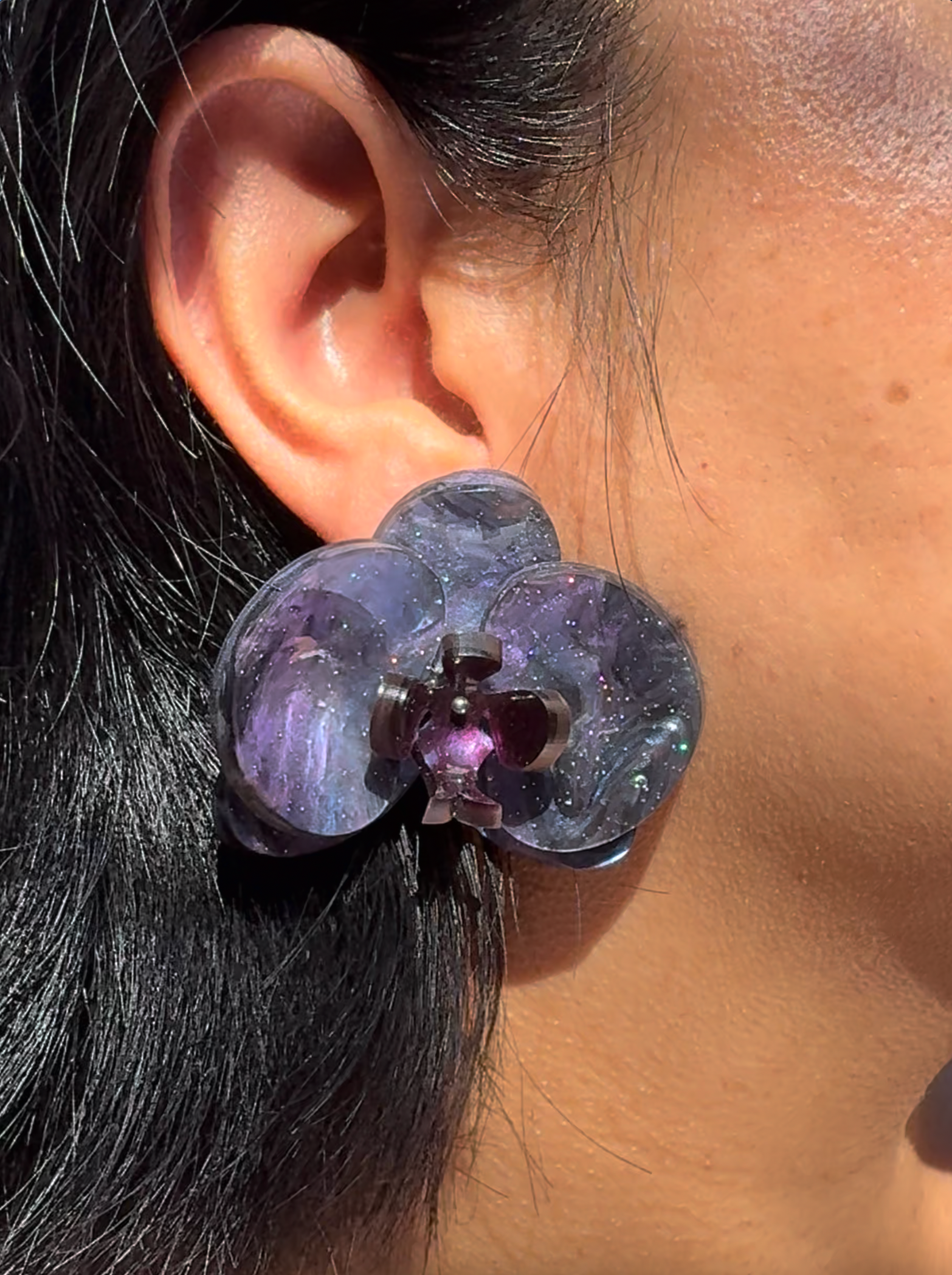 Pendientes Orquídea Cosmic Dark elaborados en metacrilato nacarado con reflejos iridiscentes